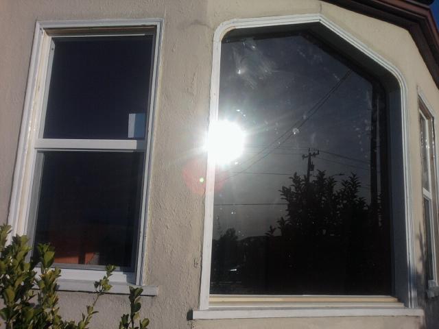 Exterior view of restored window with laminated glass installed and vinyl retrofit windows on the side